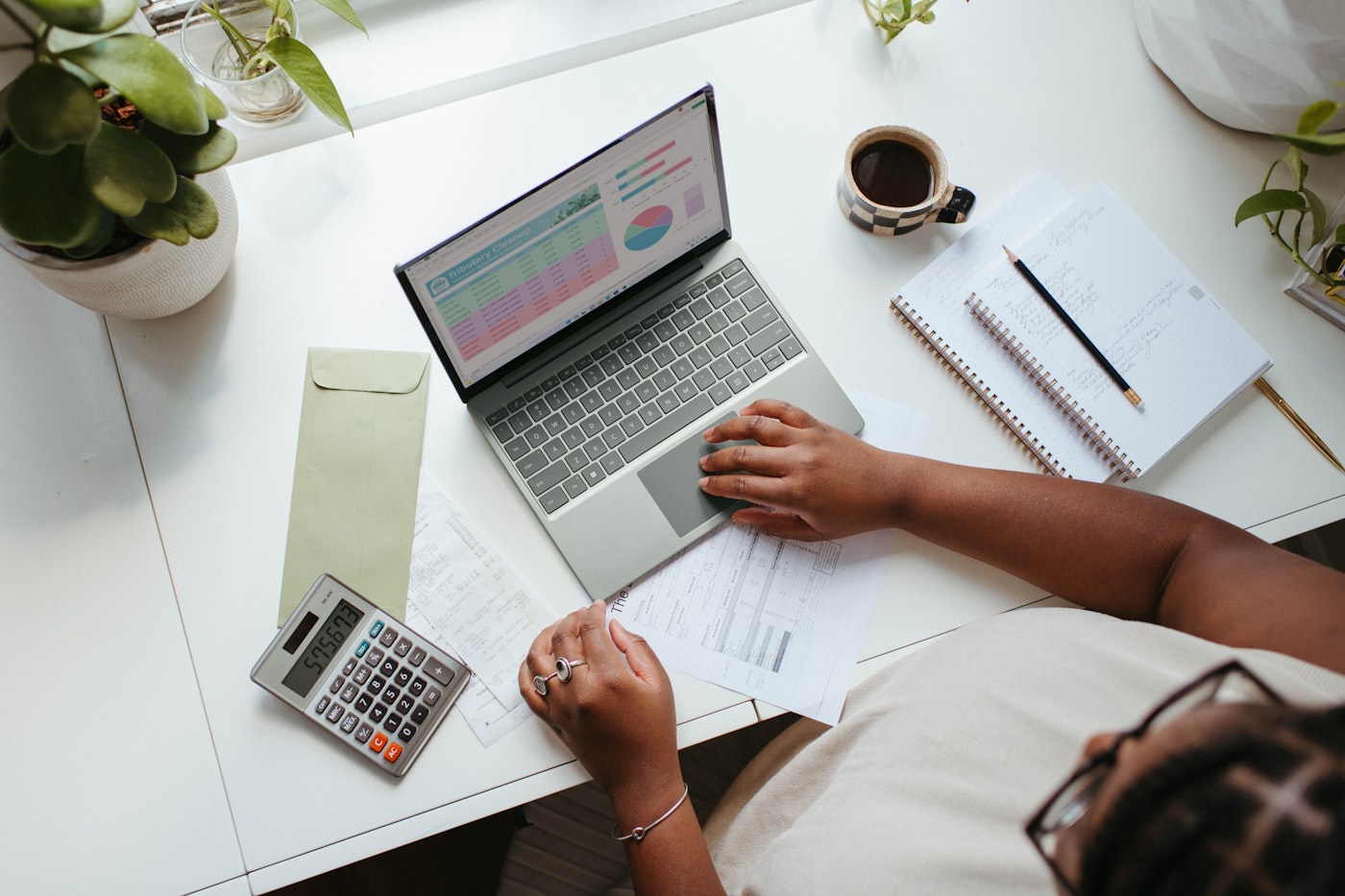 Pessoa organizando as finanças com notebook e calculadora